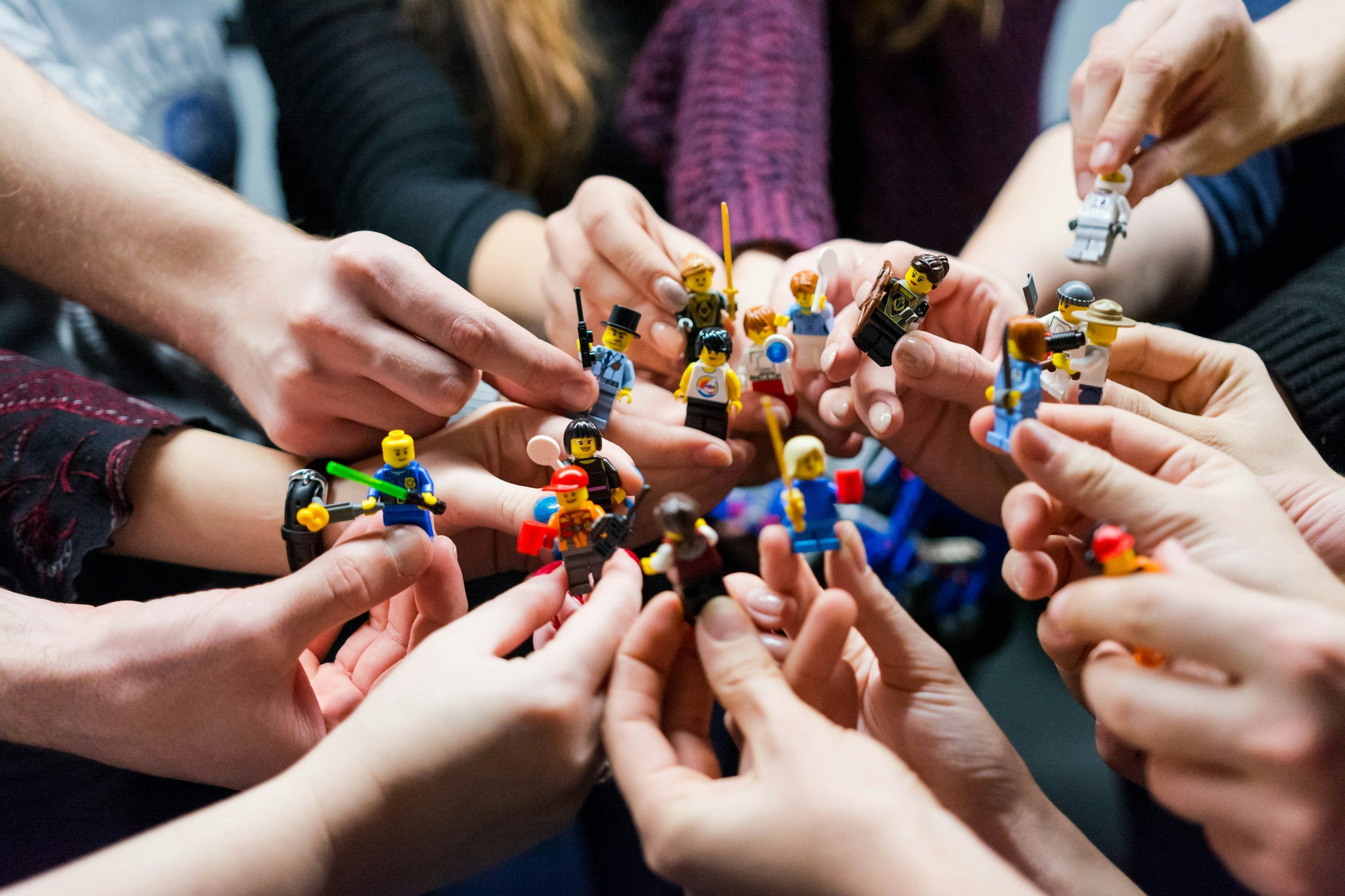 Nahaufnahme einer Gruppe von Menschen, die Lego-Figuren in den Händen halten